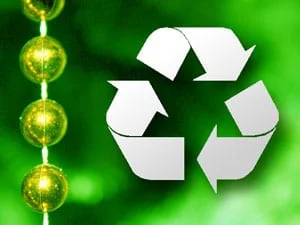 A white recycling symbol on a green background, with a string of yellow fairy lights along the left side.