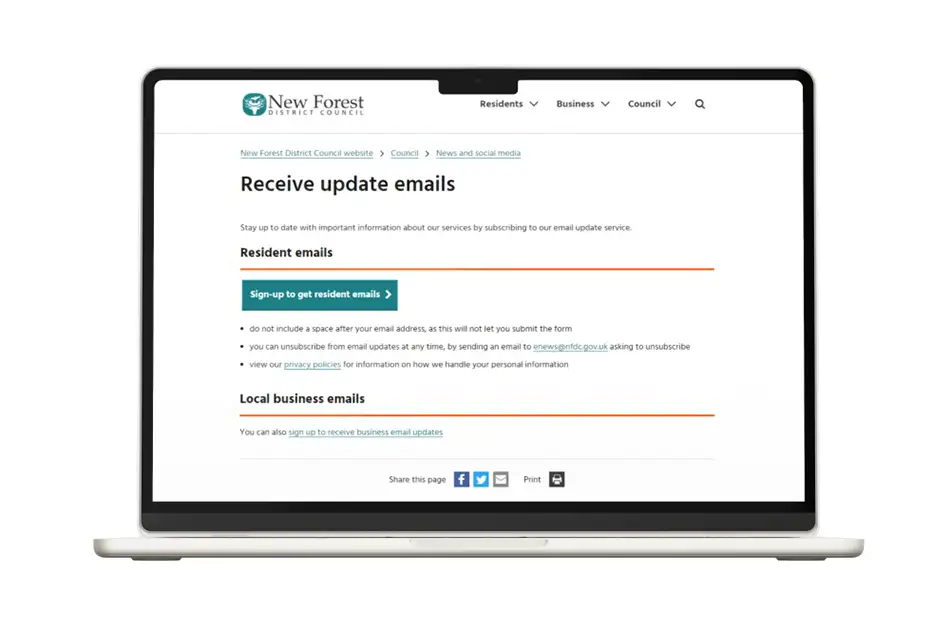 A laptop screen displays the New Forest District Council website page for receiving update emails, with sign-up options for residents and local business email updates.